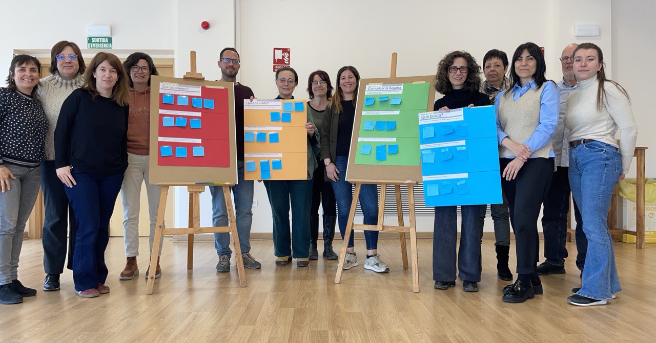 Persones assistents a la sessió de treball, amb els pòsters del que s'ha avaluat, a la sala galeria de l'Ateneu de Guissona